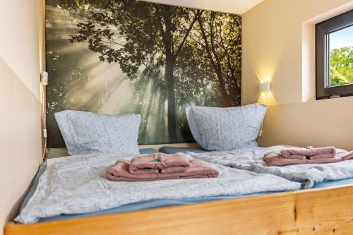 a bedroom with a bed with towels on it at Nova Ferienhaus, 50qm in Ueckermünde