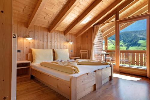 a bed in a room with a large window at Paracia App Pic Pec in Badia
