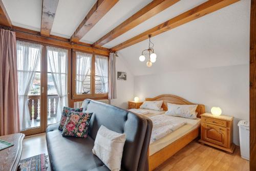 a bedroom with a bed and a couch at Gästehaus Weingut Mangel in Endingen