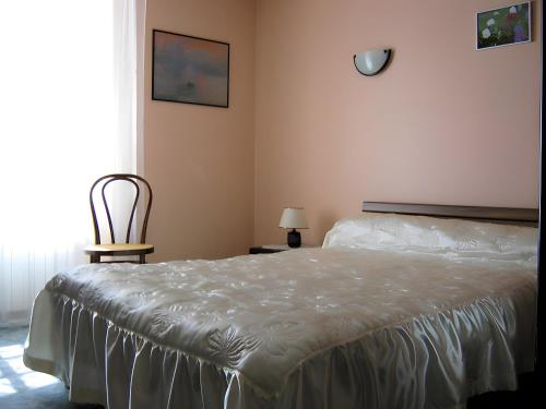 a bedroom with a bed and a chair and a window at Appartement T3 chambre d'hôte in Panazol