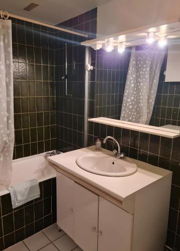 a bathroom with a sink and a tub and a mirror at Appartement T3 chambre d'hôte in Panazol