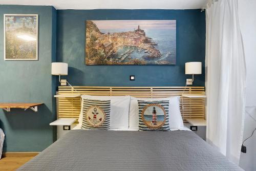a bedroom with a bed with a painting on the wall at Ca Du Grifun - Vernazza in Vernazza