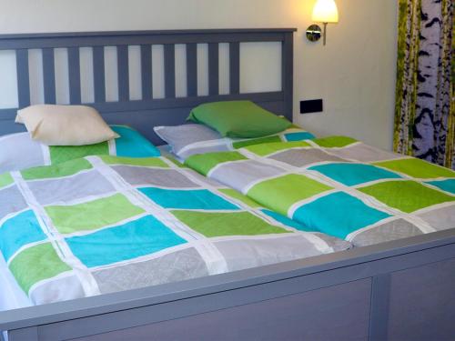 a bedroom with two beds with green and white blankets at Fewo Meisennest, 50 Qm in Saalhausen