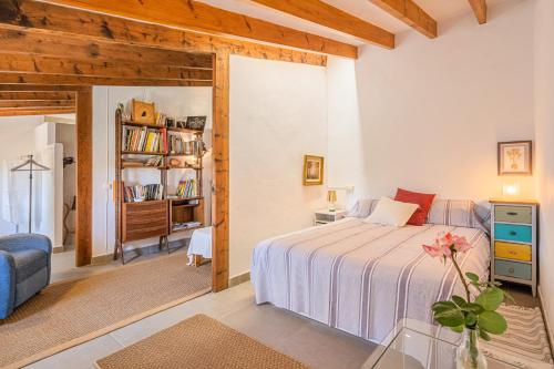 a bedroom with a bed and a couch and a table at Son Sunyer in La Aranjasa