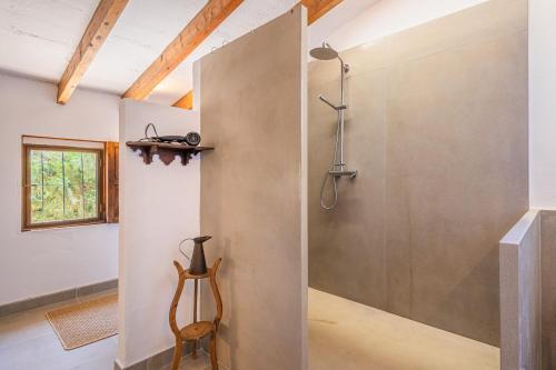 a bathroom with a shower and a wooden chair at Son Sunyer in La Aranjasa