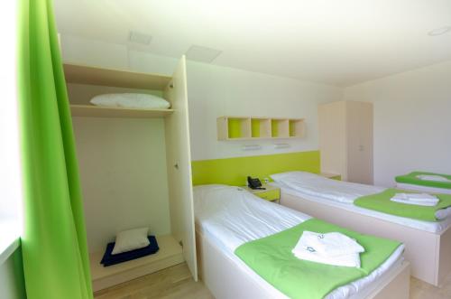 two beds in a room with green and white at Sport Hotel Ljubljana in Ljubljana