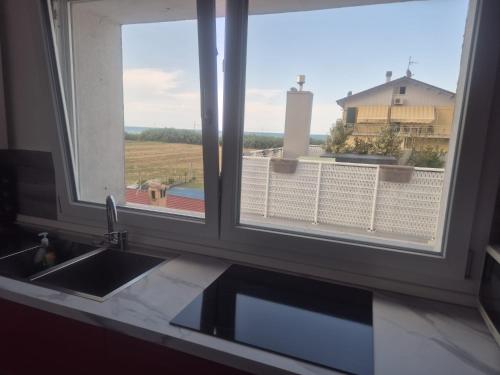 a kitchen with a sink and two windows with a view at Piccolo Chalet Comfort E Stile in Marotta