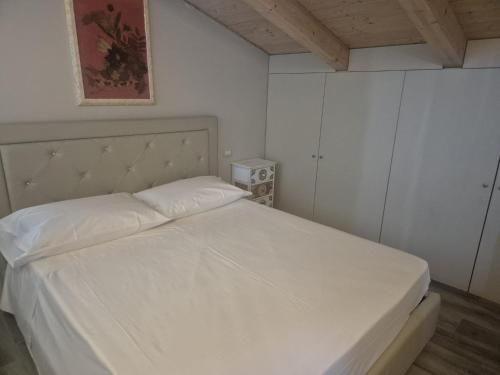 a bedroom with a white bed with a headboard at Piccolo Chalet Comfort E Stile in Marotta