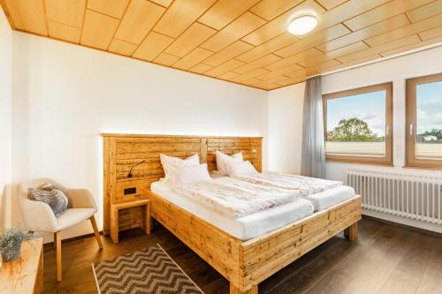 a bedroom with a bed and a chair and a window at Chalet Am Scheidt in Medebach
