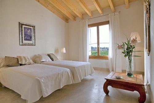 a bedroom with two beds and a vase of flowers on a table at Son Puca 1 in Búger