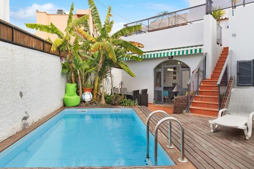 a swimming pool in the backyard of a house at Villa Garajau House in Caniço