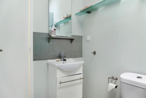 a white bathroom with a sink and a toilet at Villa Garajau House in Caniço