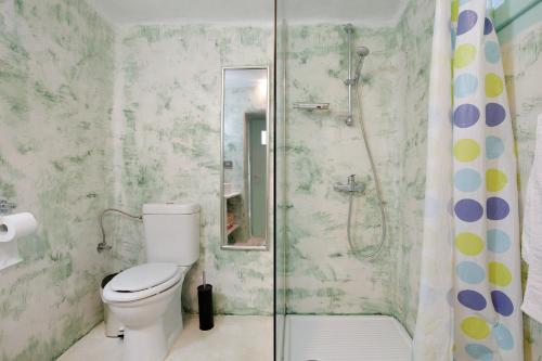 a bathroom with a toilet and a glass shower at Sira Stonehouse l in Volímai
