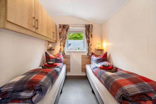 two beds in a small room with a window at Haus Ferdi in Koblenz