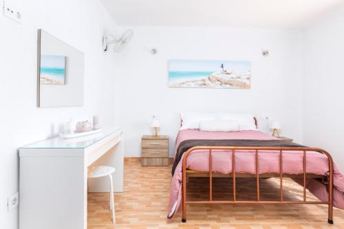 a bedroom with a bed and a desk at Villa Ralue in Tuineje