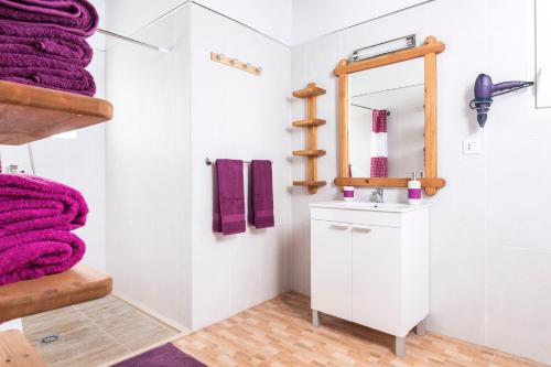 a bathroom with a sink and a mirror and purple towels at Villa Ralue in Tuineje