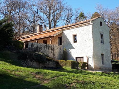an old white building on a grassy field at Maison De Campagne in Barbaste