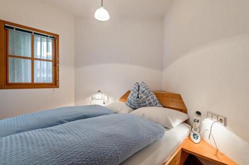 a bedroom with a blue bed and a window at Appartments Reichegger in Villa Ottone