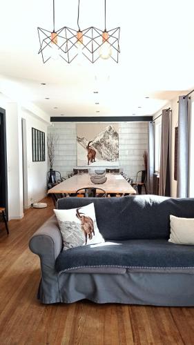 a living room with a blue couch and a table at Sublime Chalet 14 Pers Spa Extrieur in Cauterets