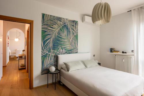 a bedroom with a white bed and a painting on the wall at Suite 51 - Arona in Arona