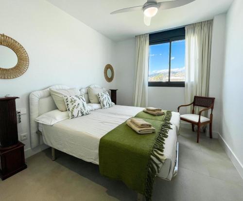 a bedroom with a bed and a chair and a window at Flat Sun Garden in Torrox