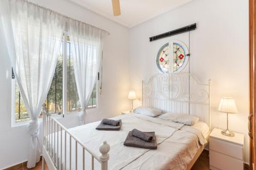 a white bedroom with a large bed with two towels on it at Villa Sueño in Mazarrón
