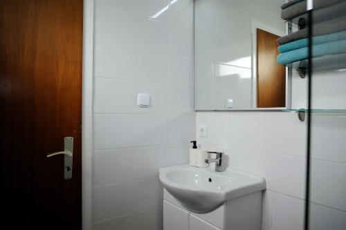 a white bathroom with a sink and a mirror at Ferienhaus Friedrichskoog - Spitze in Friedrichskoog-Spitze