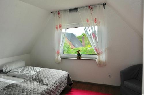 a bedroom with a bed and a window at Ferienhaus Friedrichskoog - Spitze in Friedrichskoog-Spitze