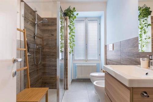 a bathroom with a shower and a toilet and a sink at Appartamento Le Quattro Stagioni in Levico Terme