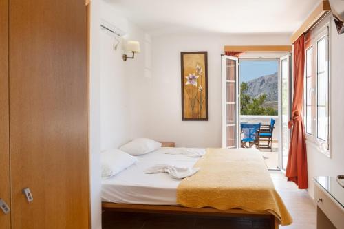 a bedroom with a bed with a view of a balcony at Calliope Maille Family House in Kalymnos