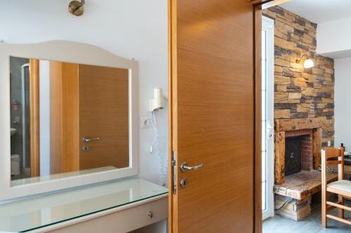 a wooden door in a room with a fireplace at Calliope Maille Family House in Kalymnos