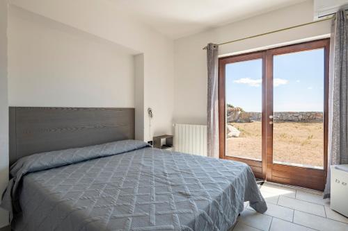 a bedroom with a bed and a sliding glass door at Casa Ami in Arzana