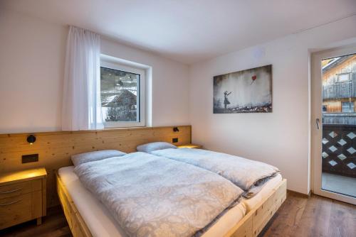 a bedroom with a large bed and a window at Apartments Armeri Blue Dolomites in San Vigilio Di Marebbe