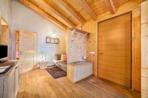 a living room with a couch and a wooden door at Grushof App Köpfl in Sluderno