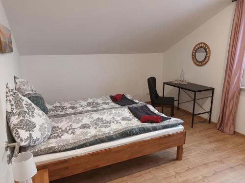 a bedroom with a bed with a chair and a table at Superior Apartment Waldblick in Westerheim