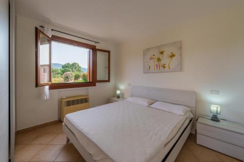 a bedroom with a white bed and a window at Casa Vacanze Susino in Olbia
