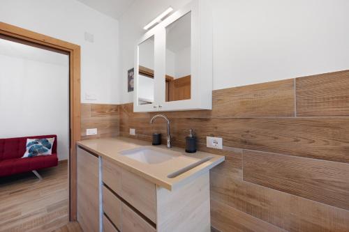 a bathroom with a sink and a red couch at Casa Loppia 2022 in Caprino Veronese
