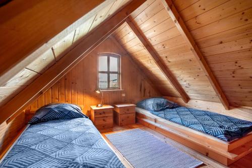 a bedroom with two beds in a wooden attic at Blockbohlen-Haus auf Hof Verchen in Verchen