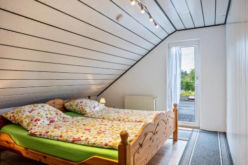 a bed in a room with a wooden ceiling at Ferienwohnung Klee in Fedderwarden