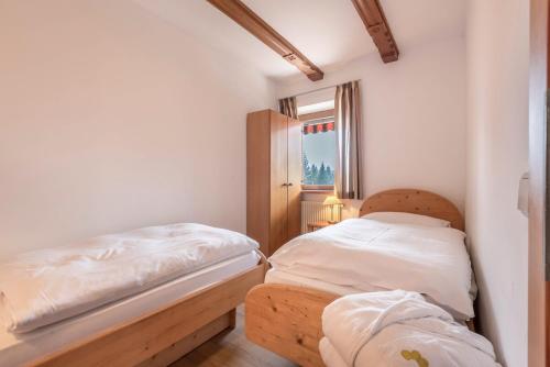 a small bedroom with a bed and a window at Sabina Dolomites Compatsch in Alpe di Siusi