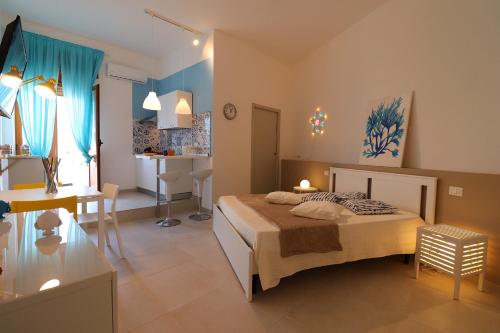 a bedroom with a bed and a desk and a kitchen at Casa Vacanze Maya a Otranto in Otranto