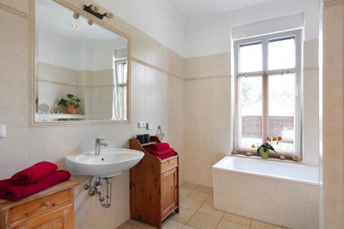 a bathroom with a sink and a tub and a mirror at Ferienwohnung Bestensee in Bestensee