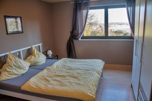 a bedroom with a bed with a large window at Ferienwohnung Maintalblick in Eltmann