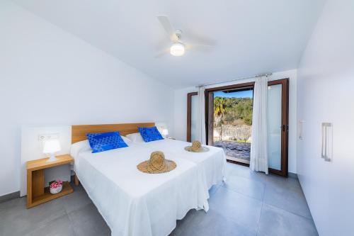 a bedroom with two beds and a large window at Can Jaume in Manacor