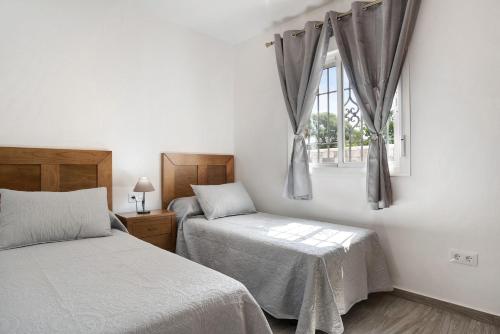 a bedroom with two beds and a window at Casa Torre De Meca 2 Shared Pool in Los Caños de Meca