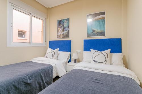 two beds in a room with blue and white at Casa Limón in Puerto Marino