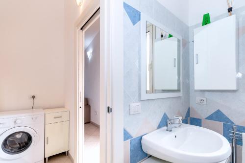 ein Badezimmer mit Waschmaschine und Waschbecken in der Unterkunft Casa Angus in Badesi