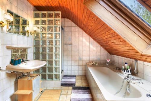 a bathroom with a tub and a sink and a window at Ferienwohnung Kudensee in Kudensee