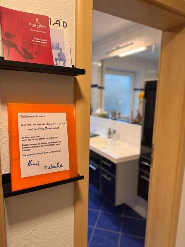 a bathroom with an orange sign on a wall at Komfort-Apartment Mit Terrasse in Estenfeld