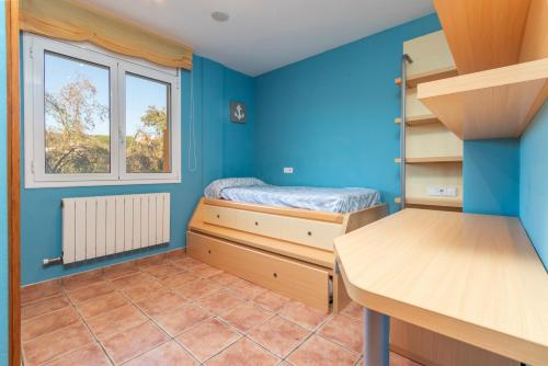 a small room with a bed and a window at Casa con piscina in Calonge